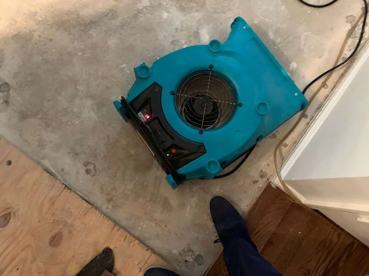 Air mover drying subfloor during Commercial Water Damage Restoration in Tracy